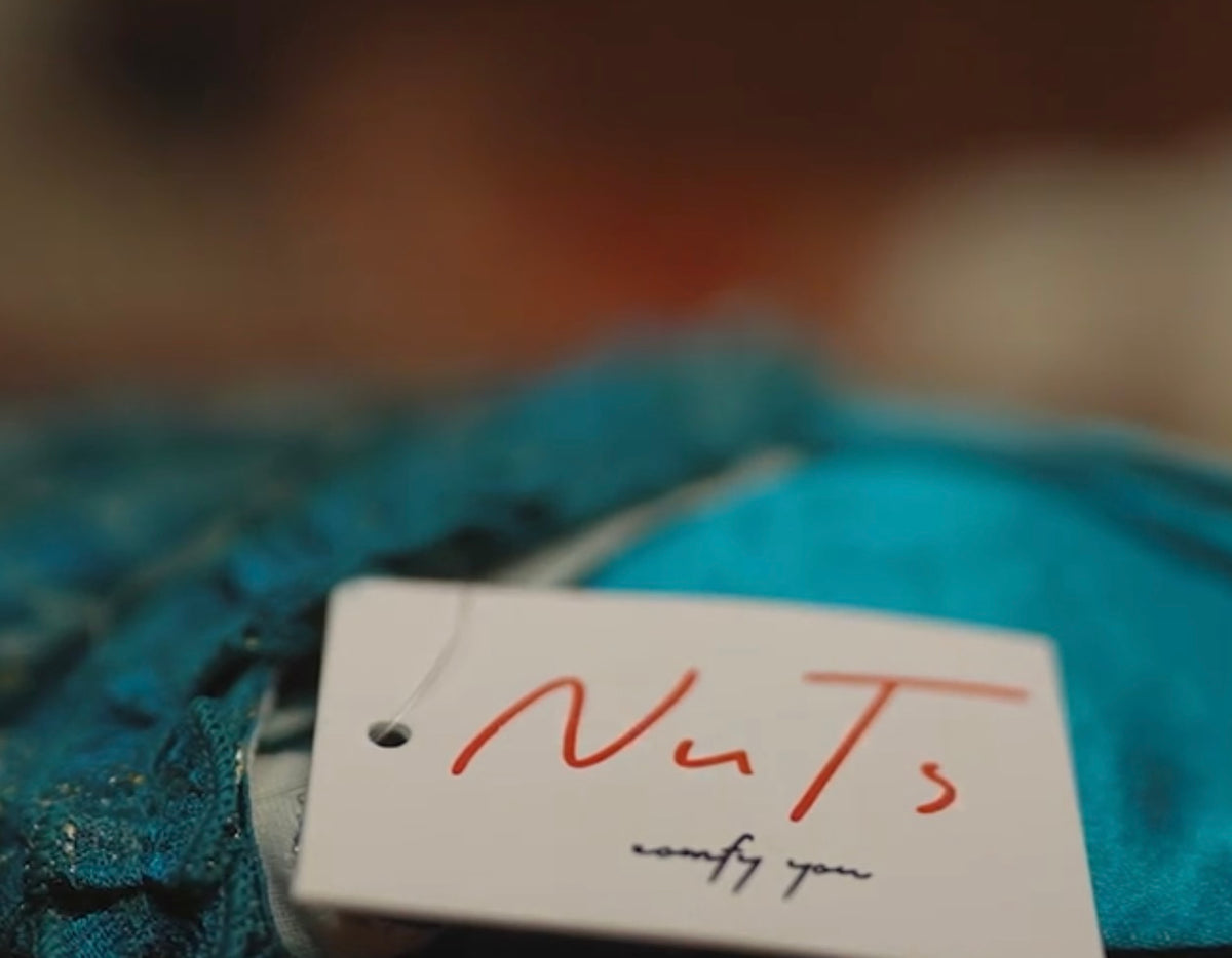 Close-up of a Nuts garment with its handwritten Nuts label